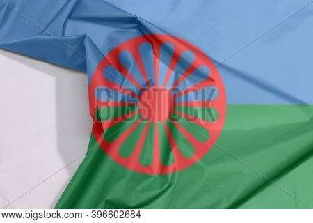 Romani People Fabric Flag Crepe And Crease With White Space, Blue And Green Background, Representing