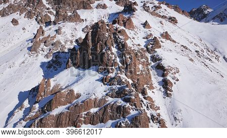 Huge Rocks Covered With Snow. Dangerous Terrain. High Mountains, Cliffs, And Large Rocks. Shadow Fro