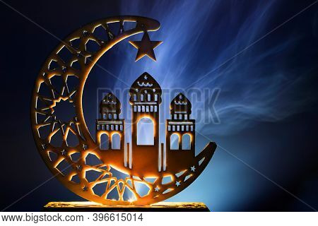 Ornamental Arabic decoraion with burning candle glowing at night and glittering golden bokeh lights. Festive greeting card for Muslim holy month Ramadan Kareem.
