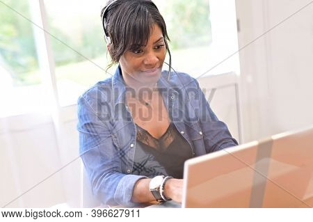Office worker woman in open space area, protected by plexiglas
