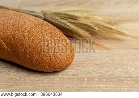 Freshly Baked Traditional Black Bread On A Wooden Table. Brown Coarse Bread Made From Shenitsa, Barl