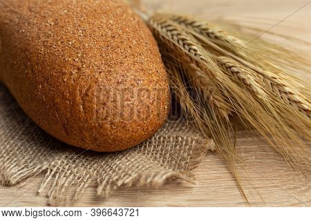 Freshly Baked Traditional Black Bread On A Wooden Table. Brown Coarse Bread Made From Shenitsa, Barl