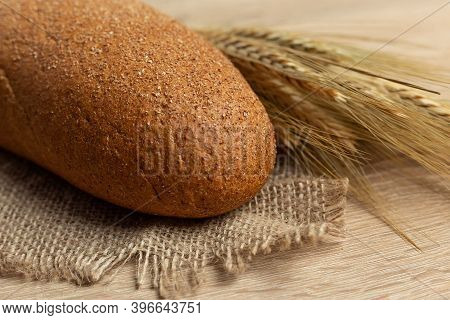Freshly Baked Traditional Black Bread On A Wooden Table. Brown Coarse Bread Made From Shenitsa, Barl