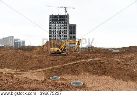Excavator Dig Trenches At Construction Site. Trench For Laying External Sewer Pipes And Sewage Drain
