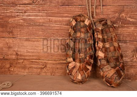 Birchen Woven Bast Shoes Hang On A Log Wall.