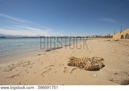 Closeup View Across An Empty Sandy Tropical Beach Shoreline In Resort To The Open Ocean With Horizon