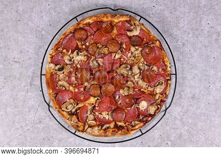 Top View Of Freshly Baked Pizza With Salami And Sujuk Sausage Slizes, Mushrooms And Mozzarella Chees