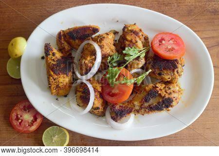 Home Made Chicken Dry Roast As A Quick Yummy Snacks Served With Onions And Tomato.
