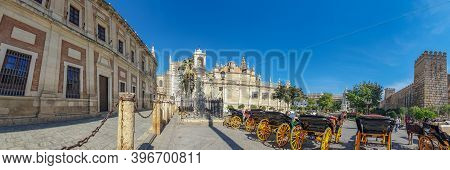 Seville, Spain - October 18. 2020: Horse Drawn Carriages At Plaza Triunfo With Tourists At The Back 
