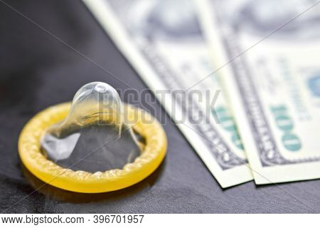 Condom On Dollars Bills. Prostitution Concept. Us Dollar Money On Table With Contraceptive. Pay For 