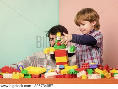 Dad And Kid Build Plastic Blocks. Child Care Development And Upbringing. Father Son Game. Father And