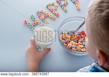 The Child Eating A Breakfast Cereal. Word With Grain Loops Happy On A Blue Background.top View