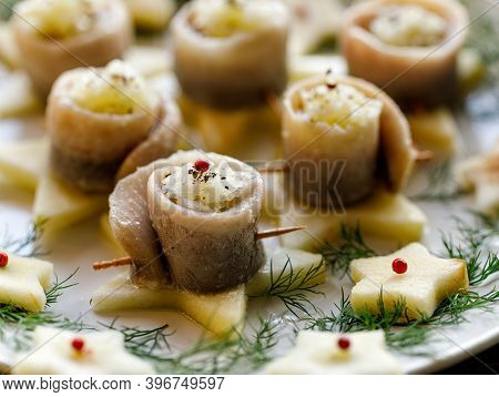 Herring Fillets Stuffed With Chopped Onions Served On Star-shaped Apple Slices Close-up View. Tradit