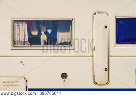 Holidays, Dventure Concept. Clothes Hanging To Dry Indoors In Camper Car Window. Viev From Outside.