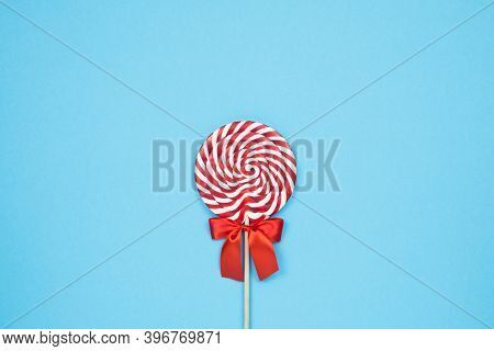 Colorful Lolipop On Blue Background, Wooden Stick, Red And White Spiral, Childhood Sweets, Christmas