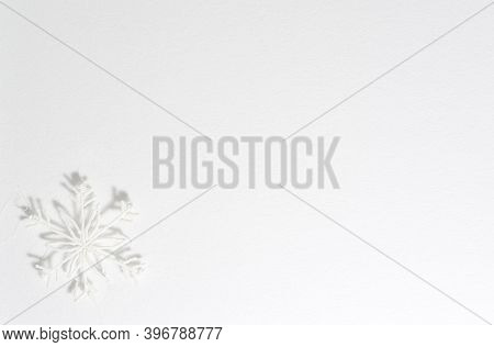 White Background With A Plastic Snowflake In The Corner, A Shadow Falls From It. Texture Of Watercol