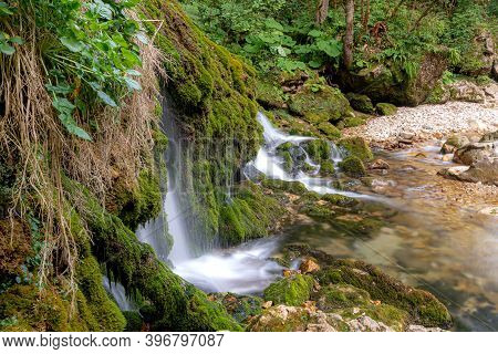 Ecology And Nature. The Source Of Clean Drinking Spring Water Among Stone Rocks And Moist Fresh Gree