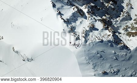 A Group Of Climbers Climb To The Top Of The Peak. Dangerous, Steep Slope. Avalanche-prone Area. Moun