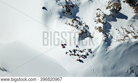 A Group Of Climbers Climb To The Top Of The Peak. Dangerous, Steep Slope. Avalanche-prone Area. Moun