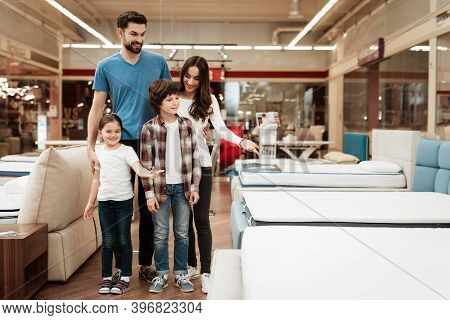 Happy Family Buys New Orthopedic Mattress In Furniture Store. Blissful Family Choosing Mattresses In