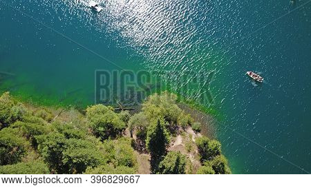 Kolsay Lake Among Green Hills And Mountains. The Mountain Lake Is Surrounded By Green Forest, Tall C
