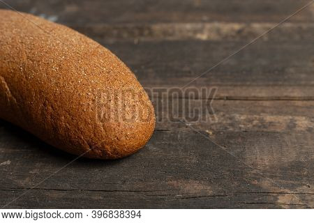 Freshly Baked Traditional Black Bread On A Wooden Table. Brown Coarse Bread Made From Shenitsa, Barl