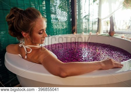 Woman Relaxing In Round Outdoor Bath With Tropical Flowers, Organic Skin Care, Luxury Spa Hotel Vale