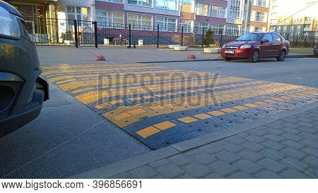 St. Petersburg, Russia - January 23, 2020: Large Wide Caution Speed Bump Near School. Cars Parked On