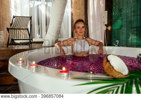 Woman Relaxing In Round Outdoor Bath With Tropical Flowers, Organic Skin Care, Luxury Spa Hotel Vale
