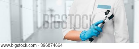 Dermatologist With A Dermatoscope Stands In The Hospital Corridor. Concept Preventive Examination Of