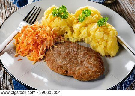 Homemade Minced Meat Cutlet Served With Mashed Potatoes And Carrot Salad.