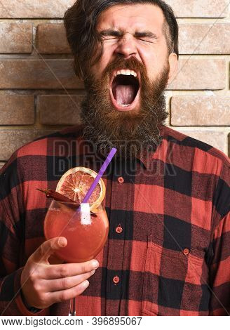 Man Holds Alcohol Cocktail On Brick Wall Background.