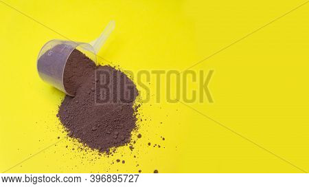 Collagen, Chocolate Protein Scattered On Yellow Background. Protein Nutrition In Sports