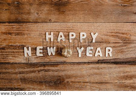 Happy New Year Inscription In Wooden Letters On A Wooden Table. Top View
