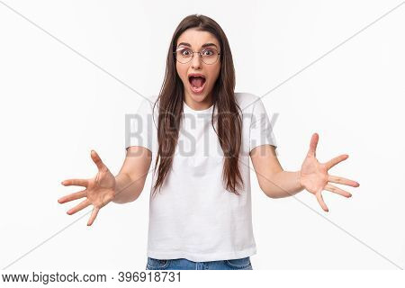 Watch Out. Alarmed And Shocked, Scared Pretty Girl Raising Hands To Catch Something That Person Thro