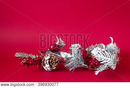 Christmas Tree Branch With Decorations On A Red Background. Place To Write