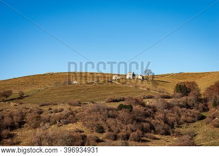 Landscape Of The Lessinia Plateau (altopiano Della Lessinia), In Autumn With Meadows, Trees And Farm