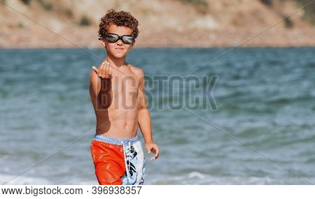 Curly-haired Boy Bathes In The Sea And Laughs
