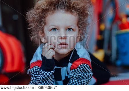 Funny Curly-haired Child Boy Expresses Funny Emotions Surprise Charismatic In A Sweater Black-and-wh