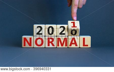 Time To 2021 Normal. Male Hand Turns A Cube And Changes Words '2020 Normal' To '2021 Normal'. Covid-