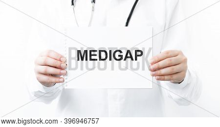 Doctor Holding A Card With Text Medigap, Medical Concept