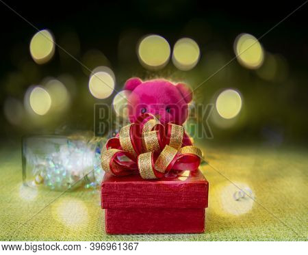 A Red Gift Box With Golden Ribbon For Celebrate Christmas And Happy New Year With A Pink Teddy Bear 