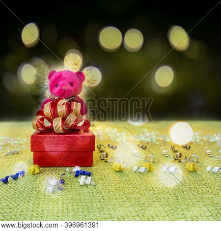 A Red Gift Box With Golden Ribbon For Celebrate Christmas And Happy New Year With A Pink Teddy Bear 