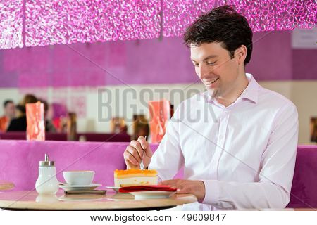 Young man in a cafe or ice cream parlor using his phone, maybe he is single or waiting for someone