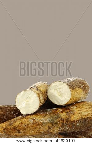 cassava root and some pieces on a brown background