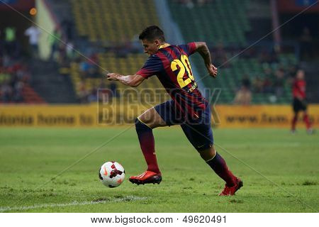 KUALA LUMPUR - AUGUST 10: FC Barcelona's Cristian Tello (maroon/blue) dribbles the ball in a match vs Malaysia at the Shah Alam Stadium on Aug 10, 2013 in Kuala Lumpur, Malaysia. Barcelona wins 3-1.