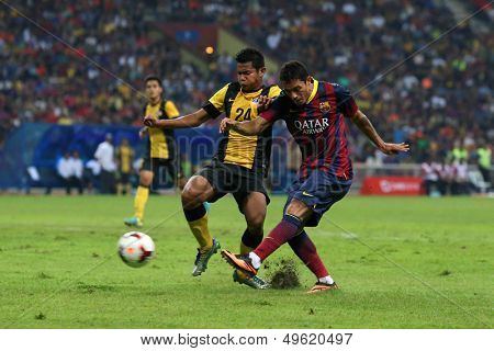 KUALA LUMPUR - AUGUST 10: Malaysia's N.M Shahrul (24) blocks a shot by Barcelona's Adriano (maroon/blue) in a friendly match at the Shah Alam Stadium on Aug 10, 2013 in Malaysia. Barcelona wins 3-1.