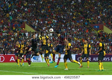 KUALA LUMPUR - AUGUST 10: Malaysia's Gurusamy (15) defends Barcelona's Sergio Busquets (maroon/blue) attack in a game at the Shah Alam Stadium on Aug 10, 2013 in Malaysia. FC Barcelona wins 3-1.