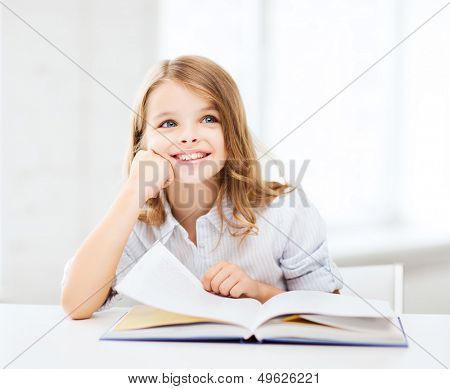 education and school concept - little student girl studying at school