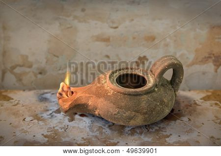 Ancient Middle Eastern oil lamp on grunge table